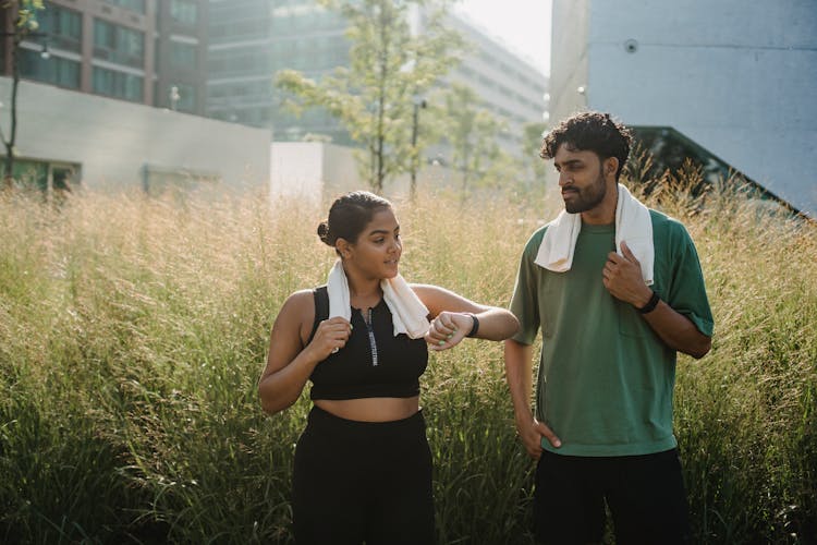 Athletic Couple Talking In Field Of Tall Grass