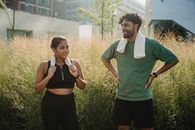 Man in Green Polo Shirt Standing Beside Woman in Black Tank Top