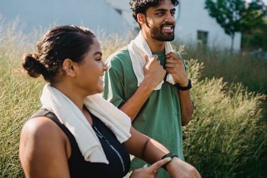 Two adults exercising outdoors with towels around necks, embracing a healthy, active lifestyle.