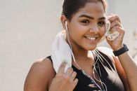 Smiling Woman in Black Tank Top With White Towel on Her Head