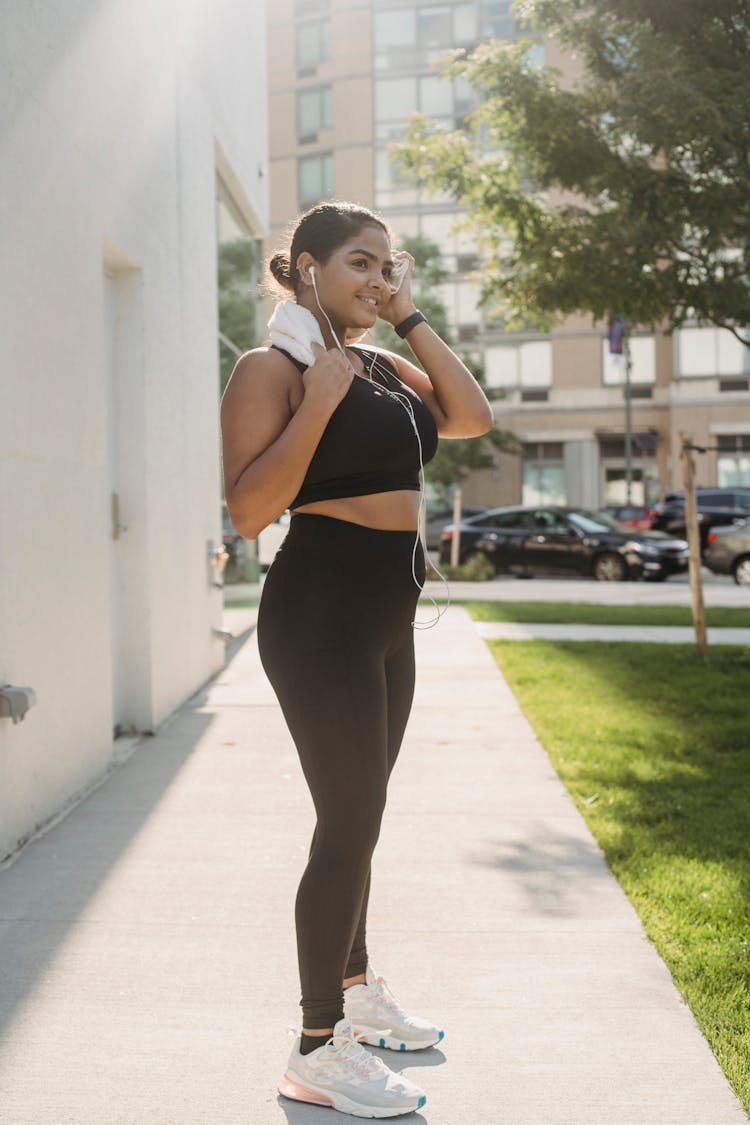 Young Woman Exercising Outdoors With Headphones