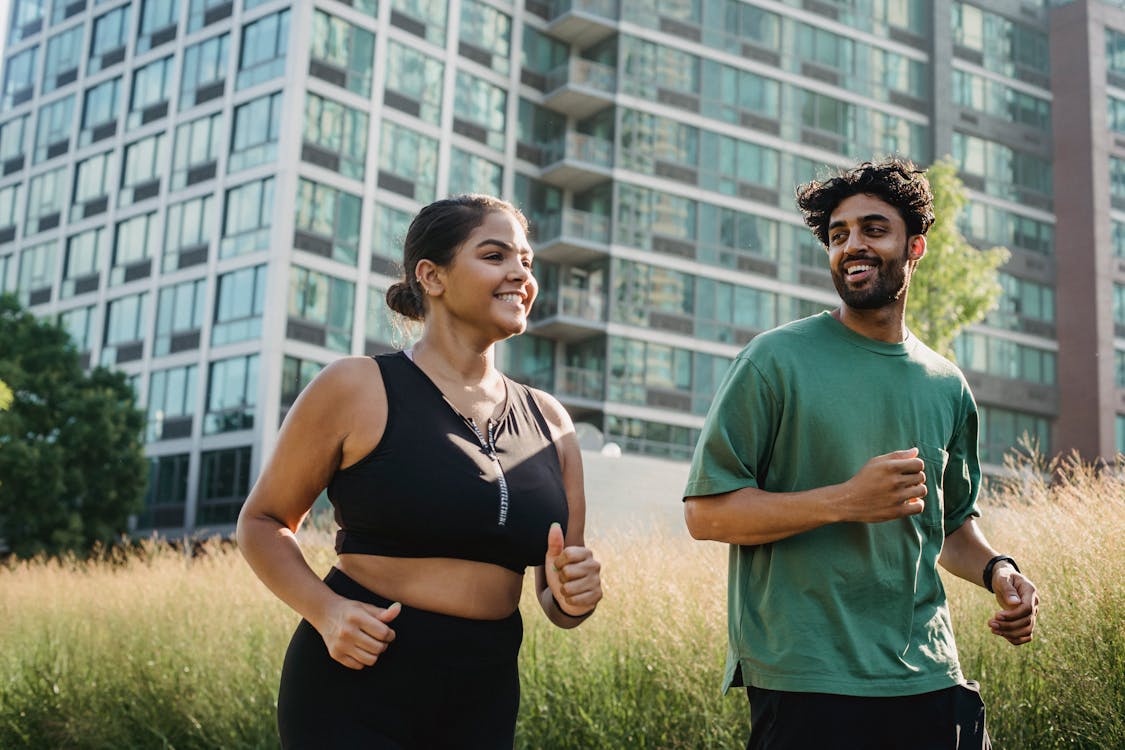 Man in Green Tank Top Standing Beside Woman in Black Tank Top