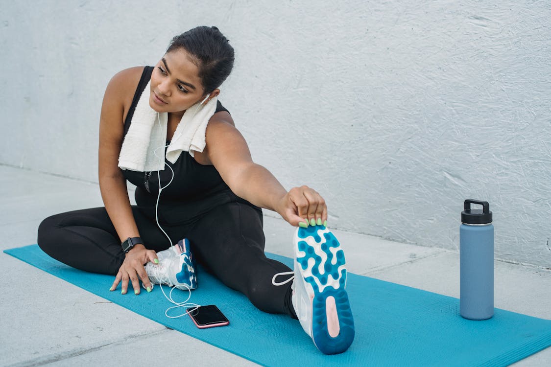 Woman stretching before posing on a mat.