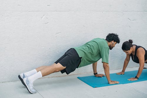 Man and Woman Exercising in Plank Position