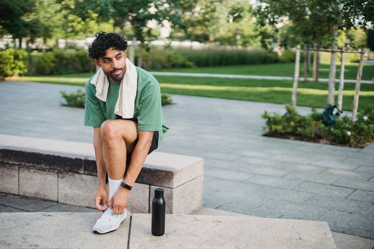 Young Man Tying Sneakers Training Outdoors