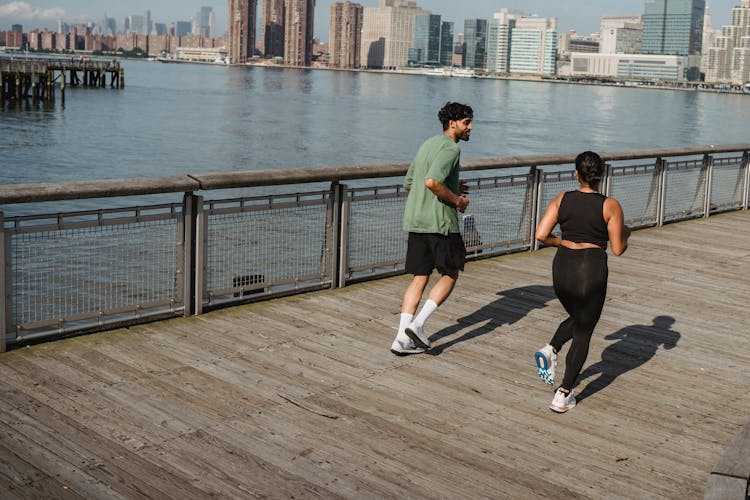 Man And Woman Jogging On Pier