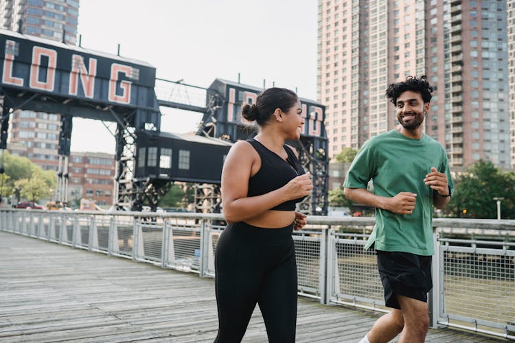 Happy Woman And Man Jogging In City