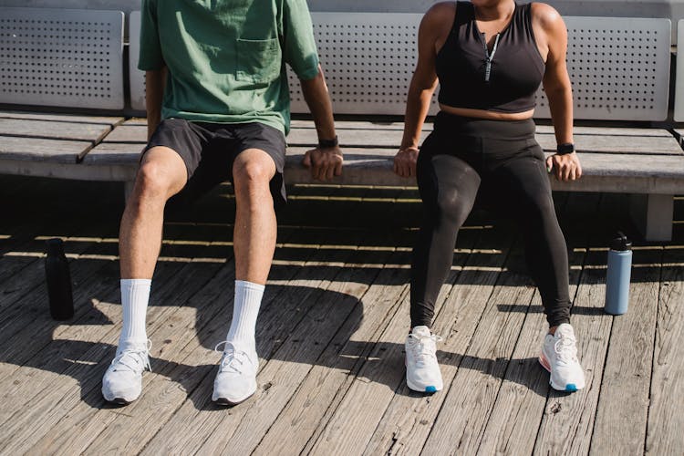 Couple Exercising At Bench Outdoors