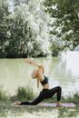 Woman in Black Sports Bra and Black Leggings Doing Yoga Near Lake