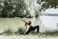 Woman in Black Sports Bra and Black Leggings Doing Yoga Near Lake