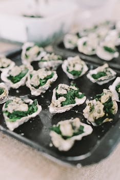 Close-up of Gourmet Oysters Rockefeller served with Spinach on baking tray.