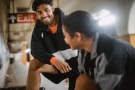 Man in Black and White Adidas Jacket Sitting Beside Man in White Shirt