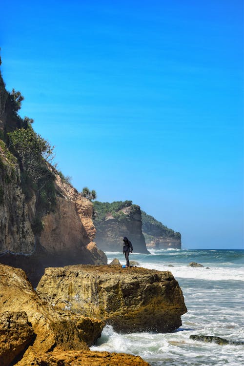 Foto profissional grátis de aventura, céu azul, litoral rochoso