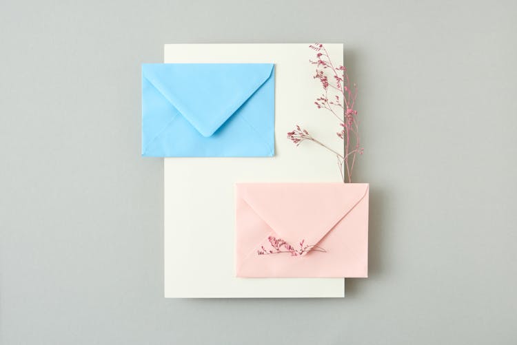 Blue And Pink Envelopes On White Sheet Of Paper