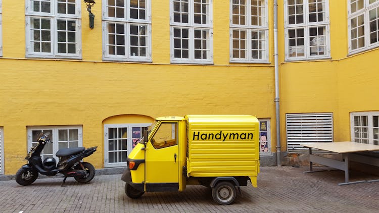 Yellow Tree Wheeler Van Parked Beside A Yellow Building