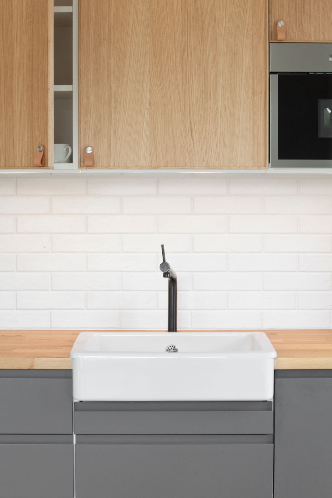 Kitchen with wood upper cabinets and leather tab pulls