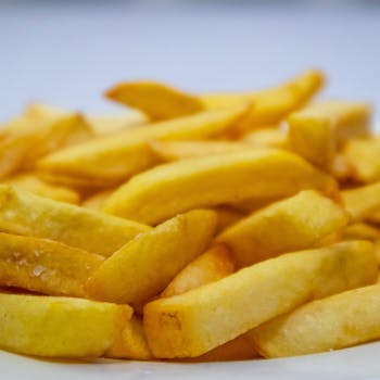 A mouthwatering close-up of crispy golden french fries on a plate.