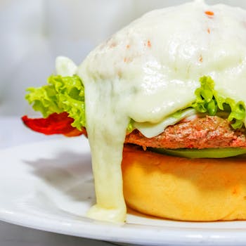 Close-up of a gourmet burger with melted cheese, lettuce, and meat, ready to serve.