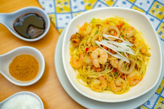 Top view of a seafood pasta dish with shrimp and spices, elegantly arranged for a gourmet experience.