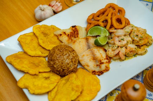 Free Tostones, Rice, Prawns, Fish and Onion Rings on a Plate  Stock Photo