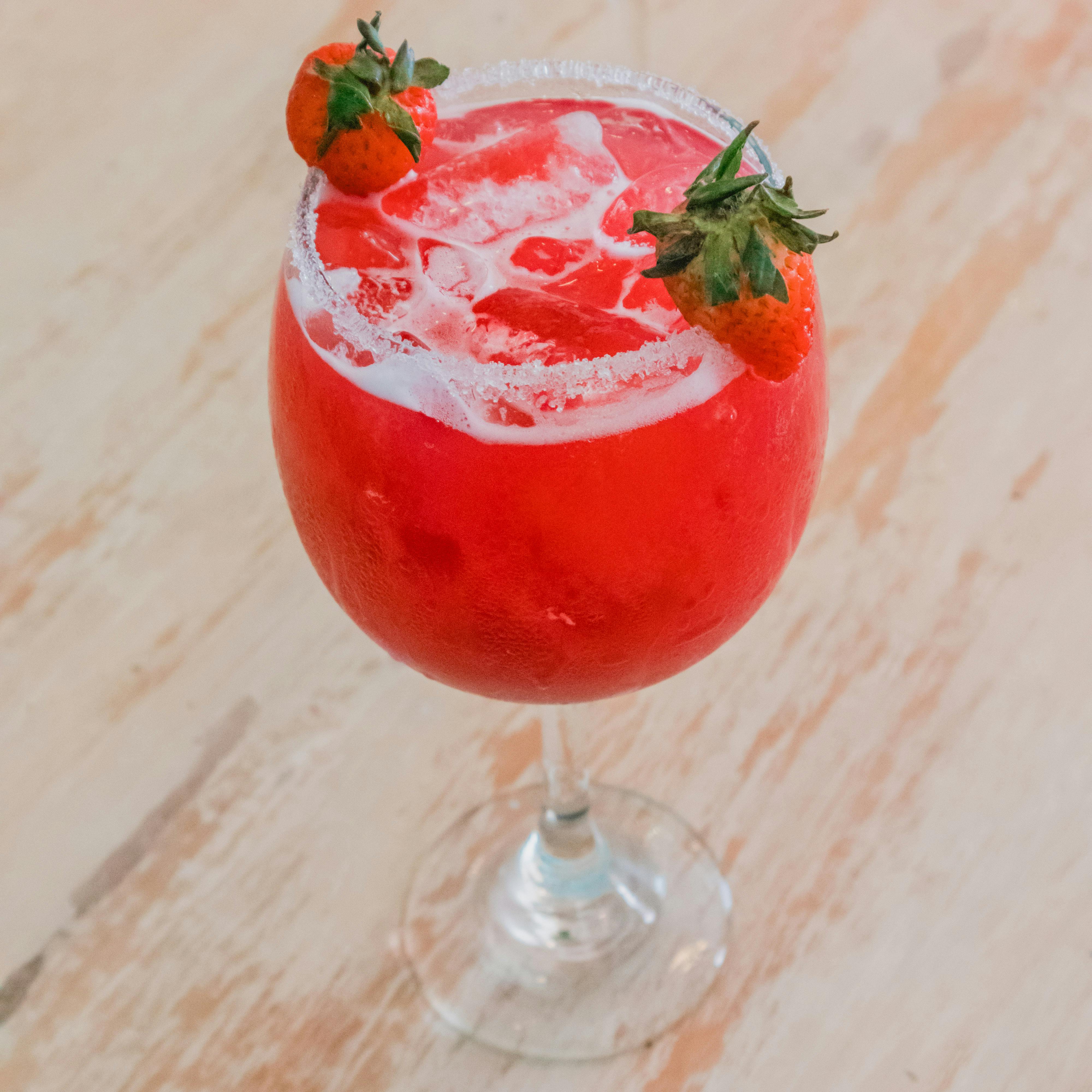 Free Vibrant red strawberry cocktail with ice, perfect for a refreshing summer drink. Stock Photo