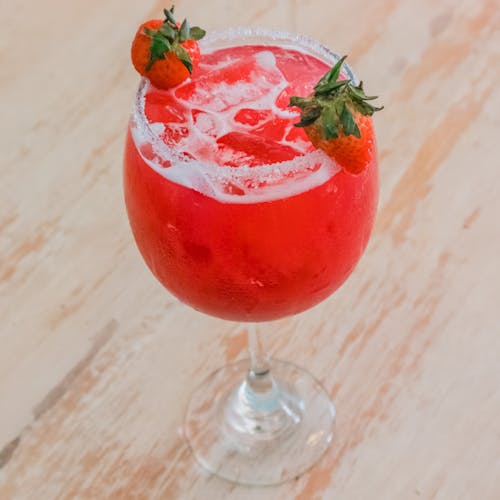Free Red Drink in a Wine Glass with Ice Cubes and Strawberries Stock Photo