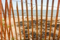 Old wooden fence on sandy beach