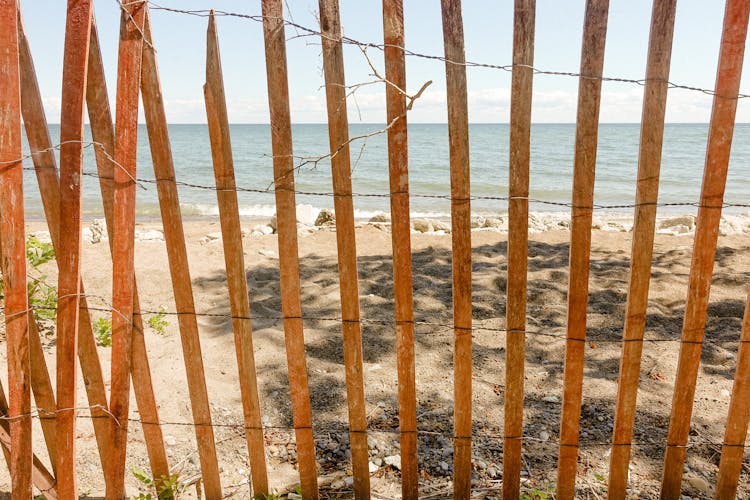 Old Wooden Fence On Sandy Beach