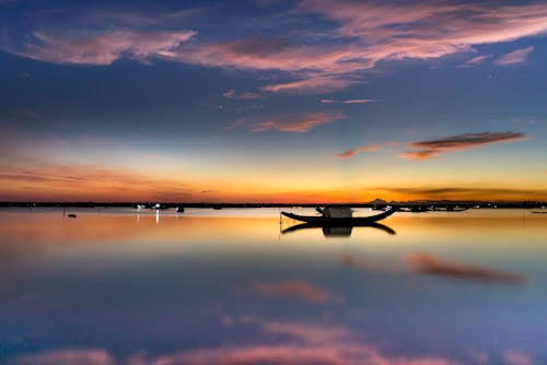 Scenic sunset over calm lake with boats