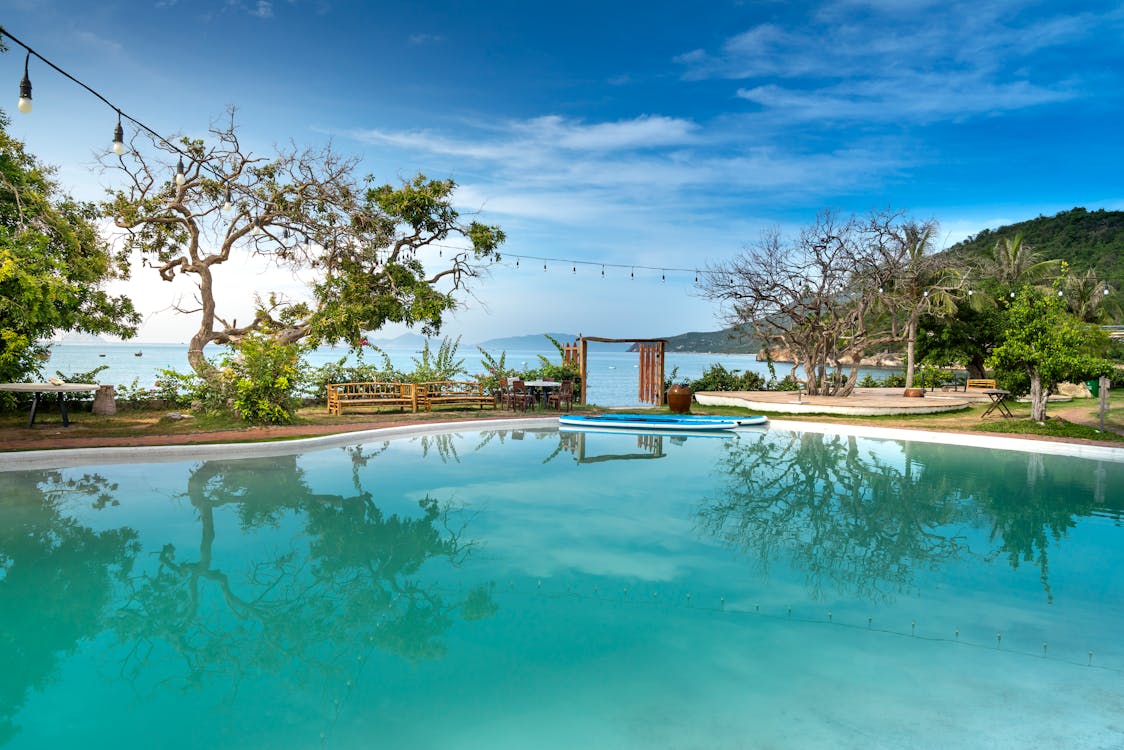 Free Swimming pool in yard of resort hotel on seashore Stock Photo