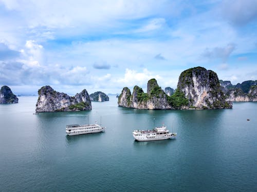 Cruise ships floating in ocean with cliffs