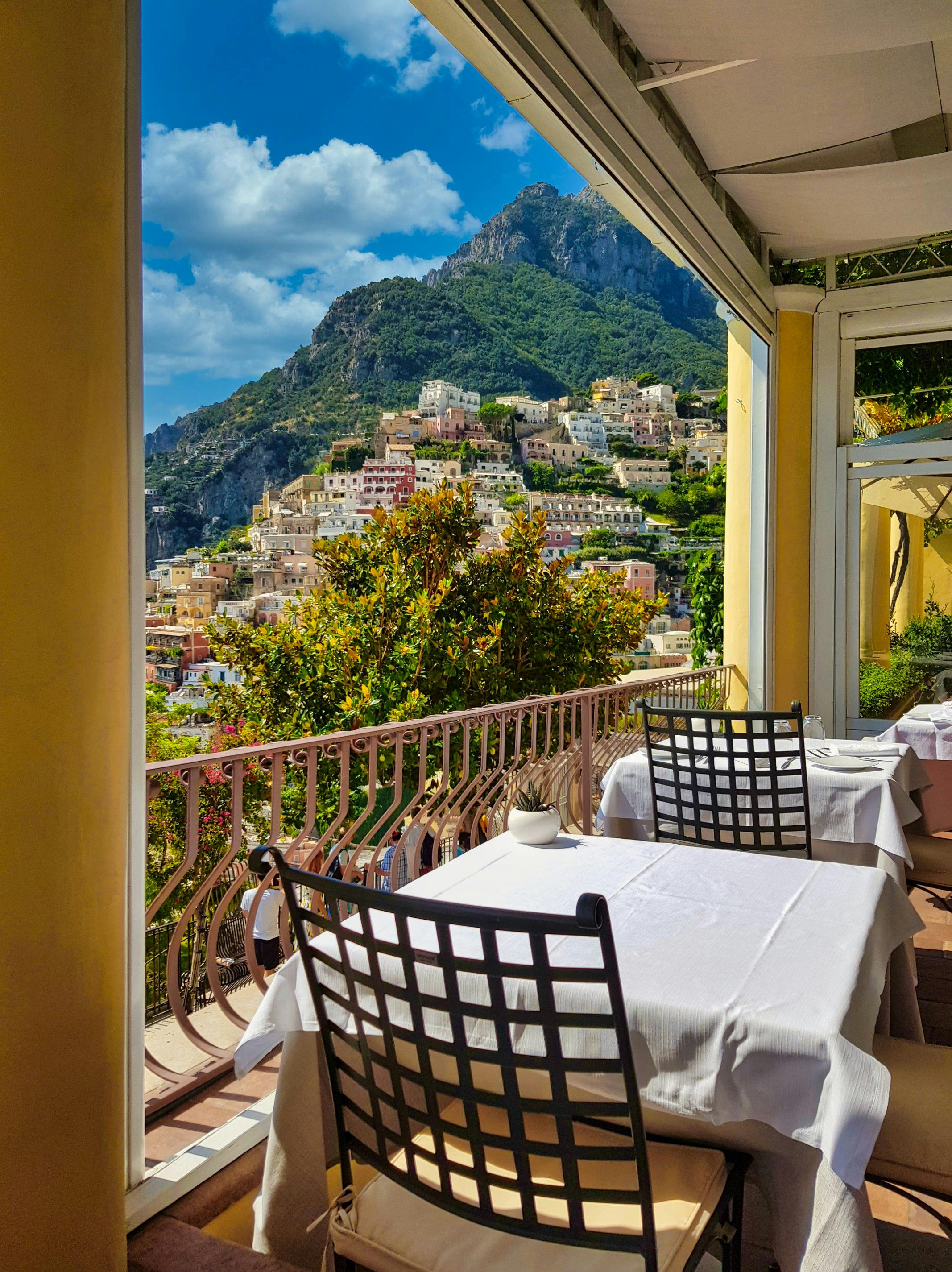 A restaurant balcony with a panoramic mountain and sea view