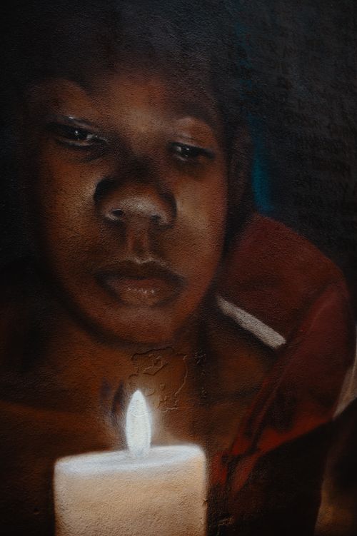 Free Oil painting illustrating crop calm African American female looking at burning candle in darkness Stock Photo
