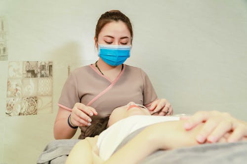 Woman Wearing a Facemask Holding a Patient