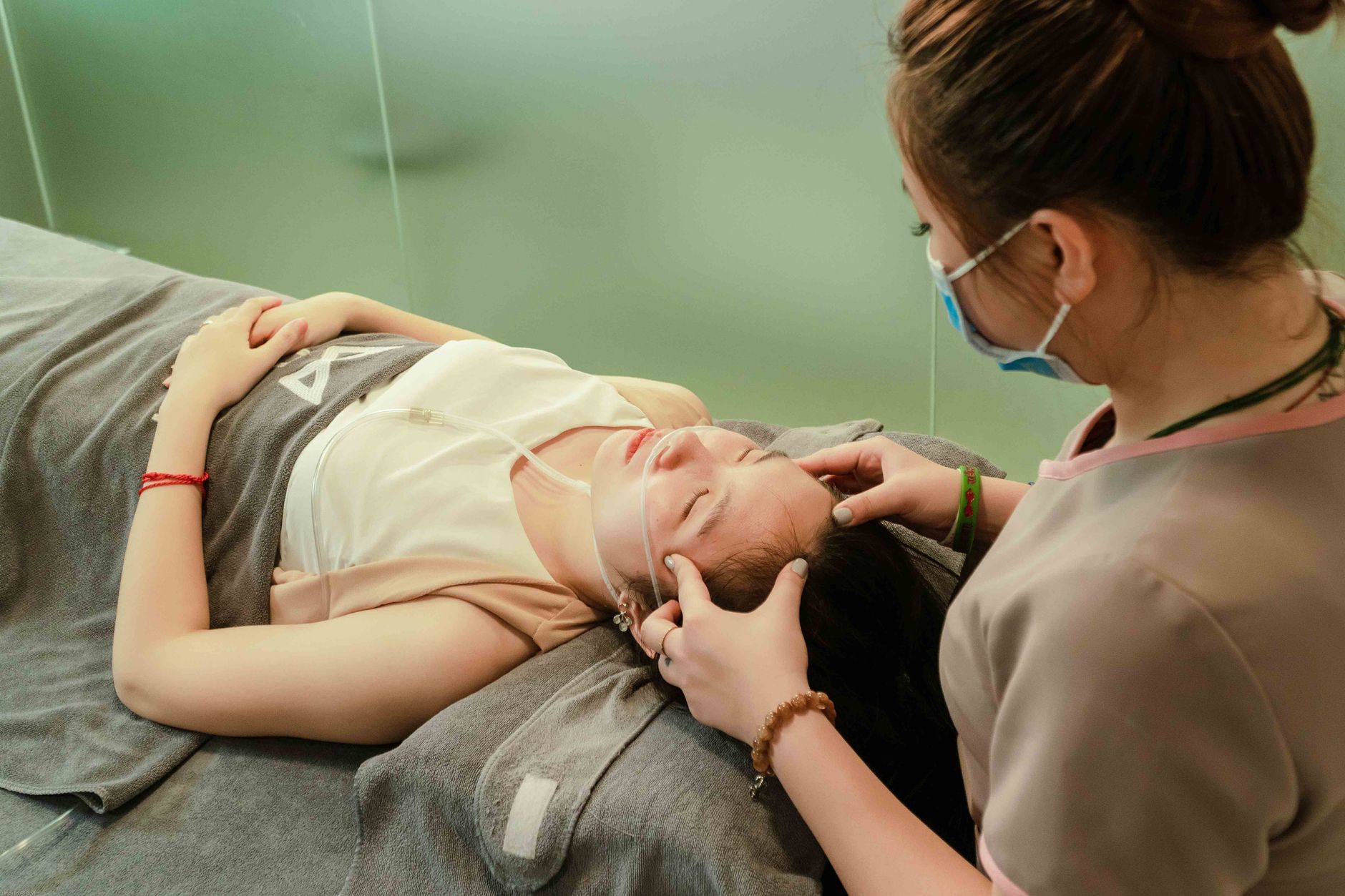Healthcare professional examining a relaxed patient in a spa setting, Hanoi, Vietnam.