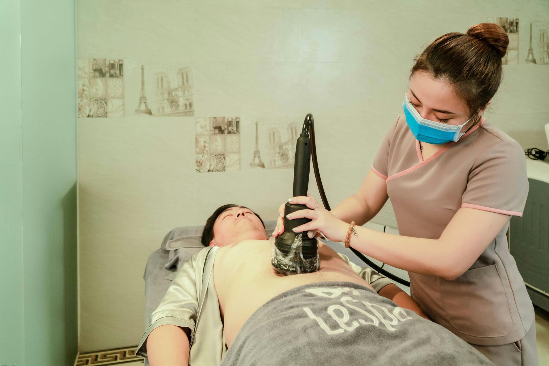 A spa therapist performs a body contouring treatment on a patient in Hanoi, Vietnam.