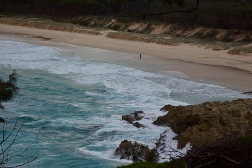 Free A tranquil beach scene with crashing waves and distant shoreline views. Stock Photo