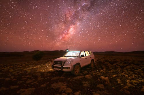 Free White Suv on Brown Field Under Starry Night Stock Photo