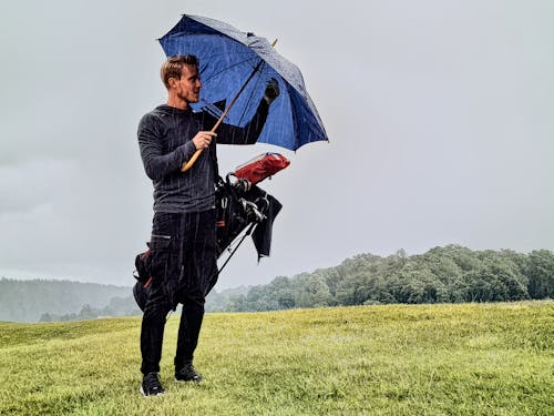 Man in Black Jacket Holding Umbrella