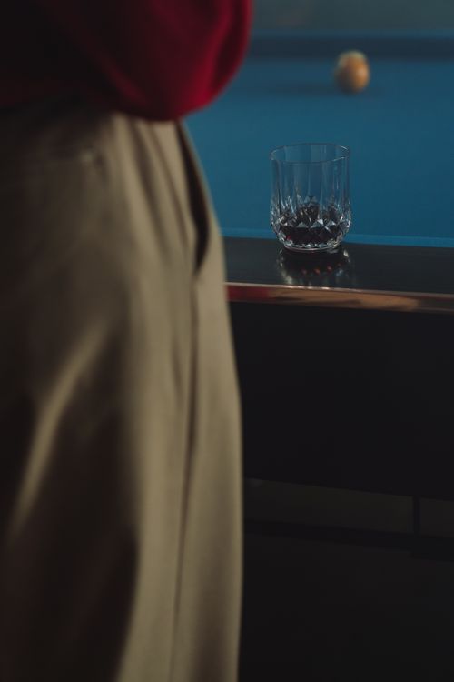 Free Crystal whiskey glass on a pool table beside a billiard ball, creating a leisure indoor setting. Stock Photo
