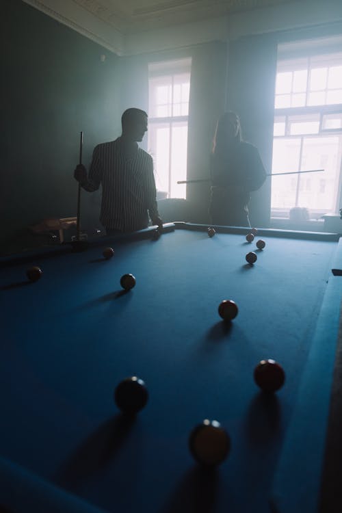 Free Man in Black and White Striped Long Sleeve Shirt Playing Billiard Stock Photo