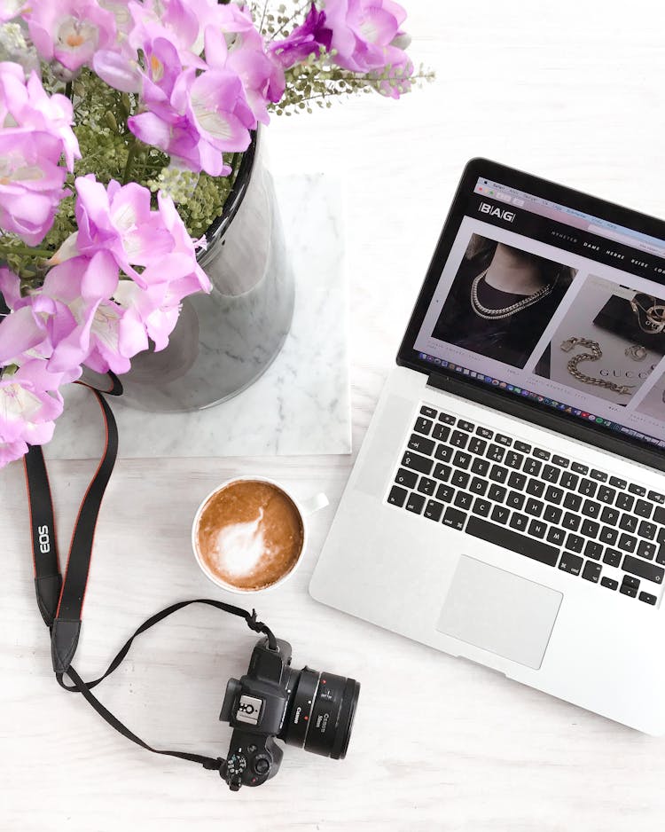 Laptop Near Mug Of Latte And Photo Camera On Table