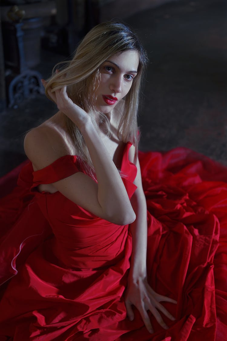 Gorgeous Woman In Red Gown Sitting On Floor