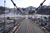 Wooden Bridge Leading to Winter Mountains