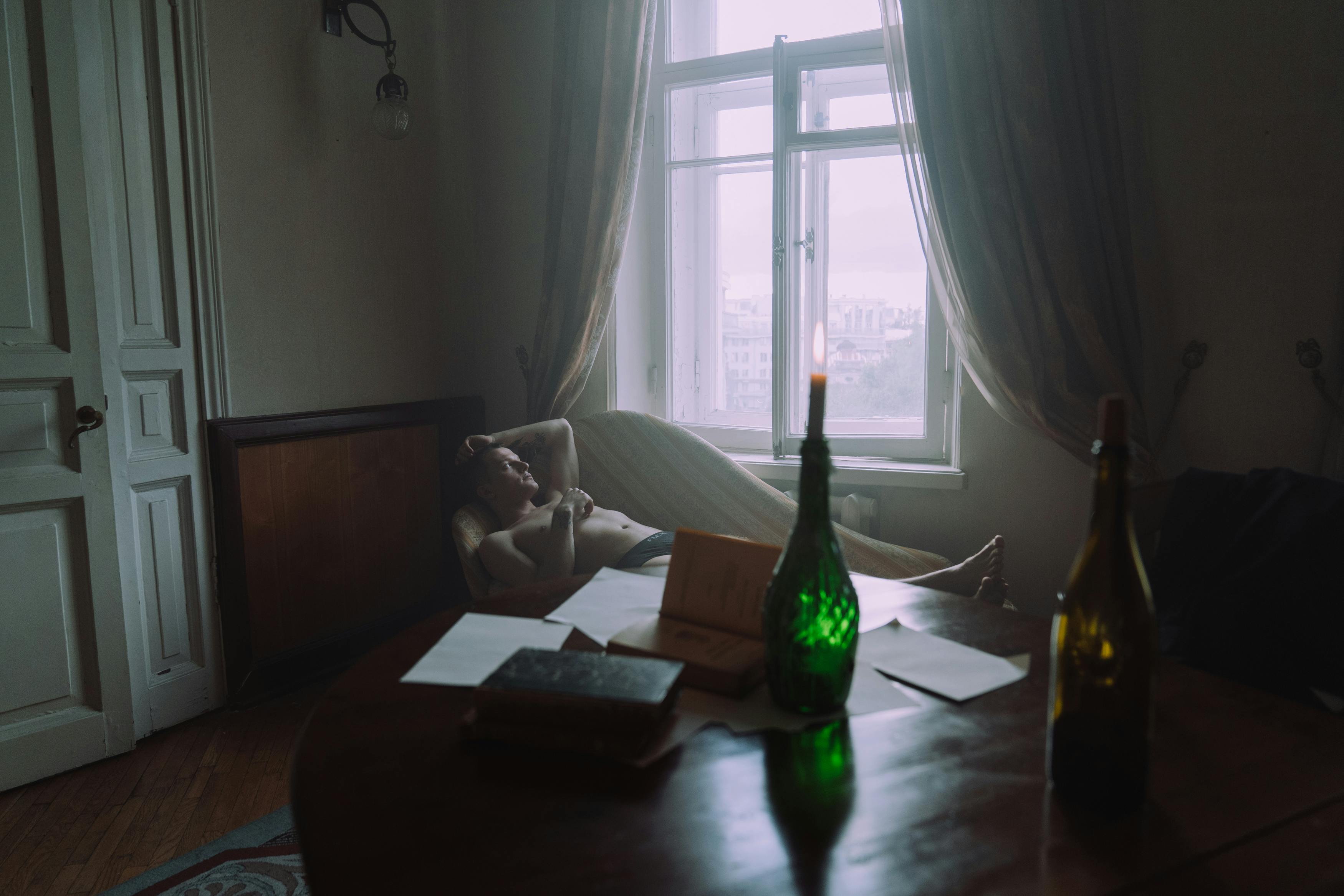 green glass bottle on brown wooden table