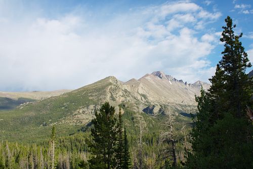 Free Breathtaking view of snow-capped mountains and lush forests under a vibrant blue sky in Cody, Wyoming. Stock Photo