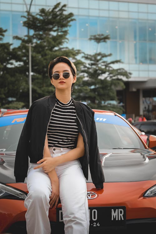 Free A Woman Sitting on the Front of a Car  Stock Photo