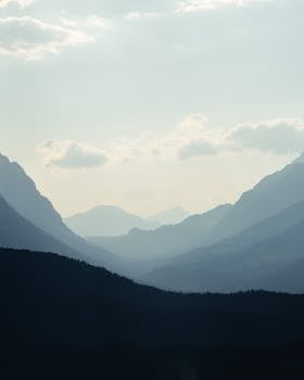 Breathtaking view of misty mountains in Seefeld, Tyrol with a serene sky.