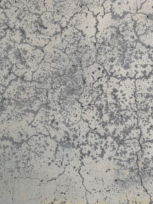 Close-up of cracked concrete wall texture, perfect for backgrounds and design elements.