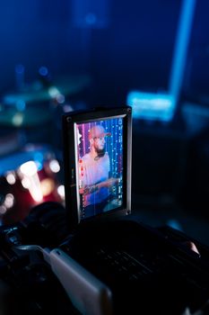 Close-up of a drummer recorded on a digital camera screen during a studio session.